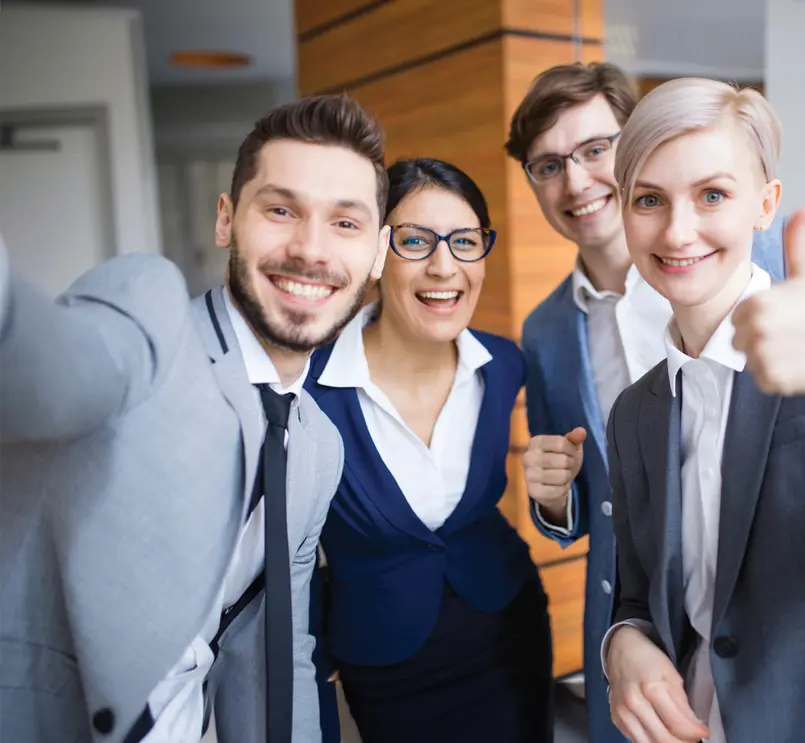 Group of smiling business professionals taking a group selfie