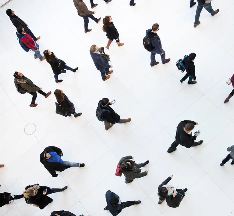 High-angle shot of people walking across a bright white floor