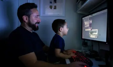 Father and son playing on computer