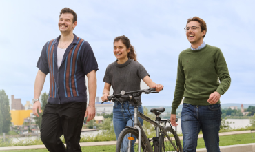 Young people walking in park with a bicycle