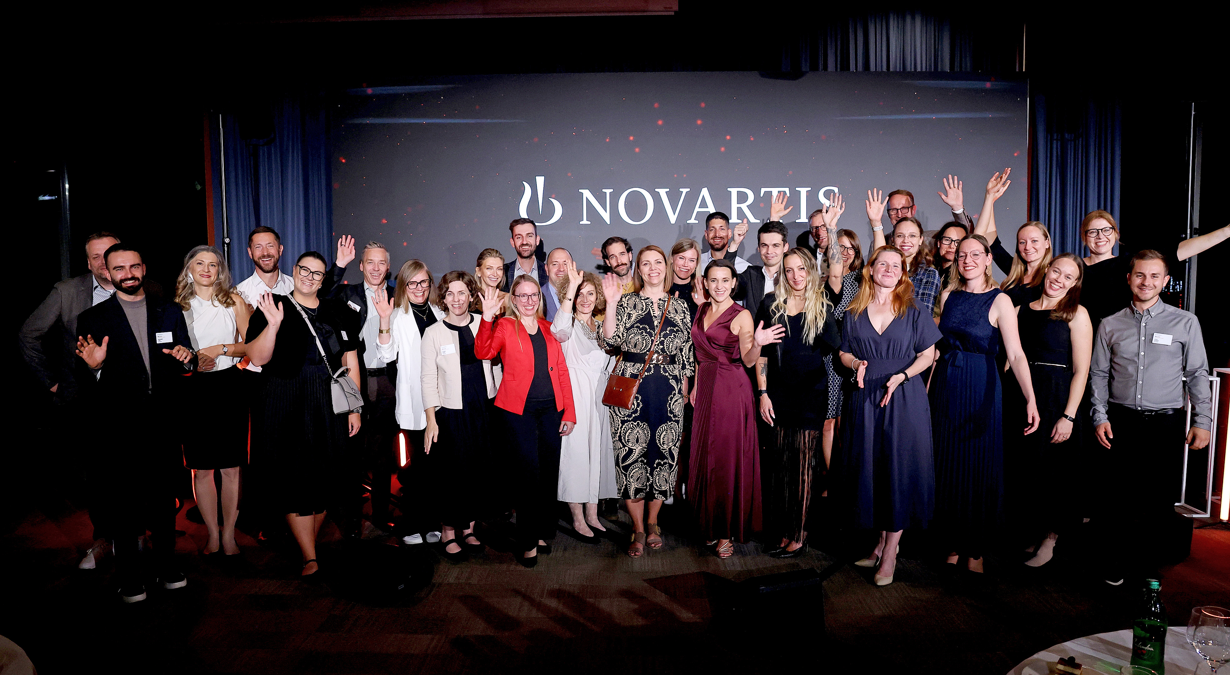 Large group photo of all participating young STEM talents and organizers on the Novartis BioCamp stage