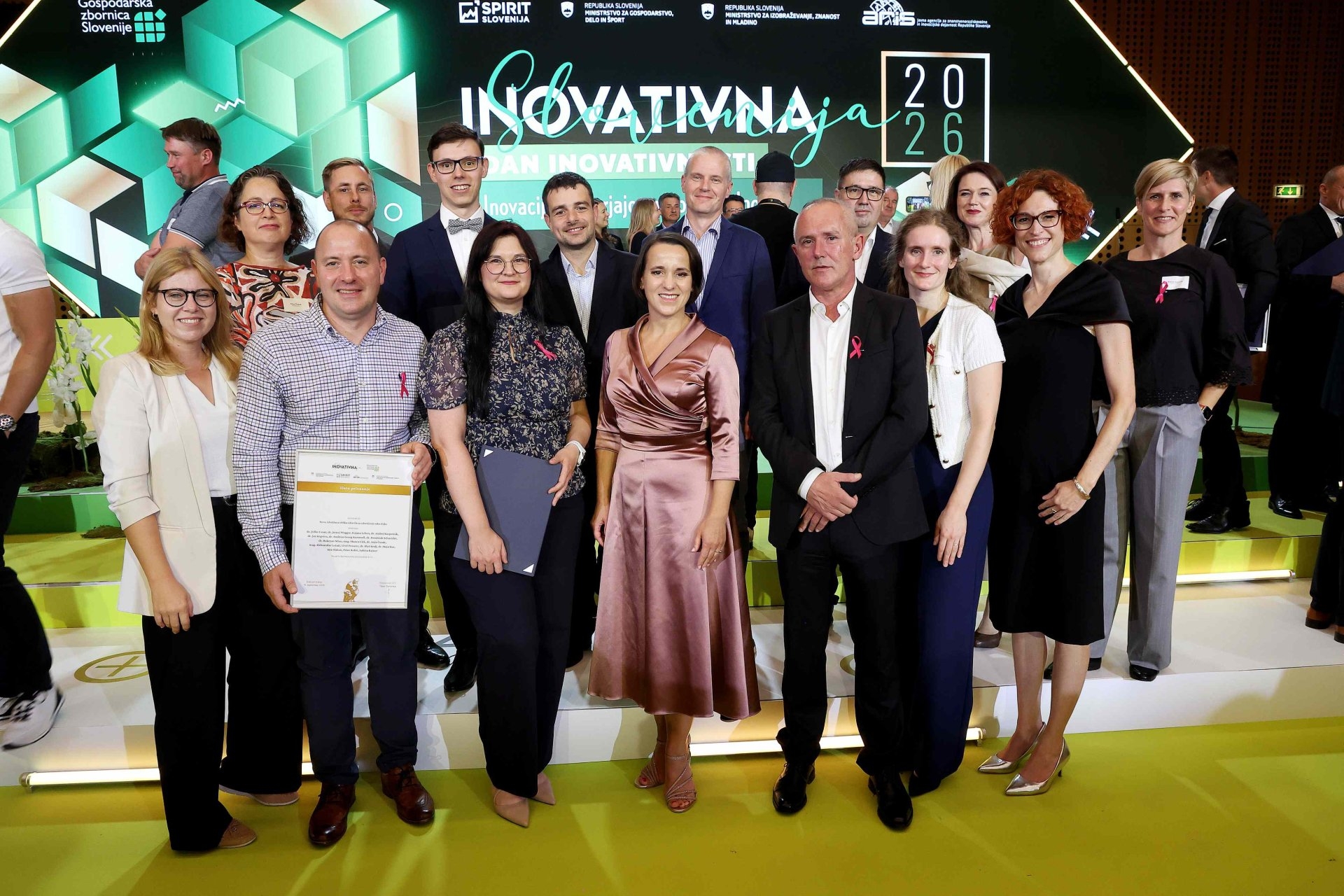 Novartis experts posing on stage with their Gold Innovation Award certificate, celebrating Novartis' Gold Recognition for breast cancer treatment innovation