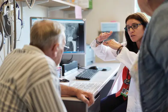 Doctor explains hip X-ray to patient using gestures