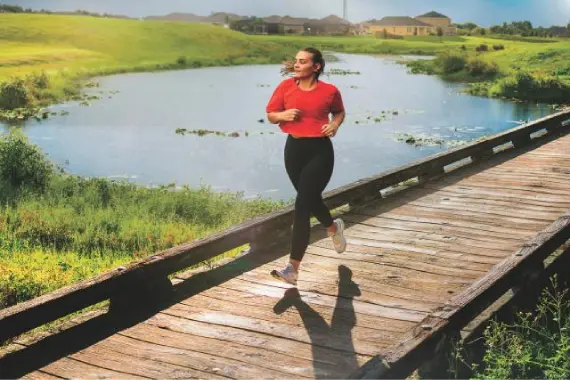 Patiently running along a wooden path near a pond