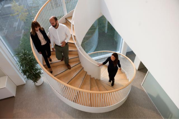 People on spiral staircase in modern office building