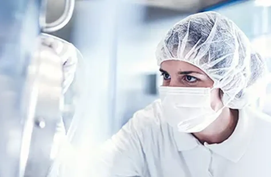 Znanstvenica v zaščitni opremi dela v sterilnem laboratoriju