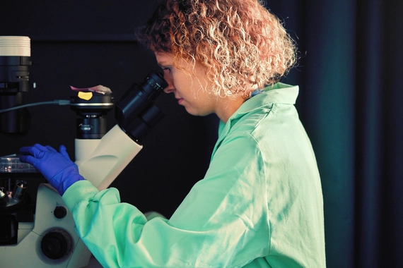 Znanstvenik uporablja mikroskop v laboratorijskem okolju