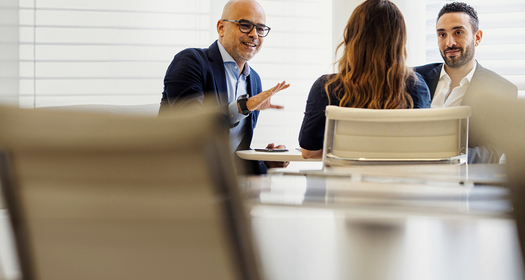 Three professionals discussing business during a meeting in an office