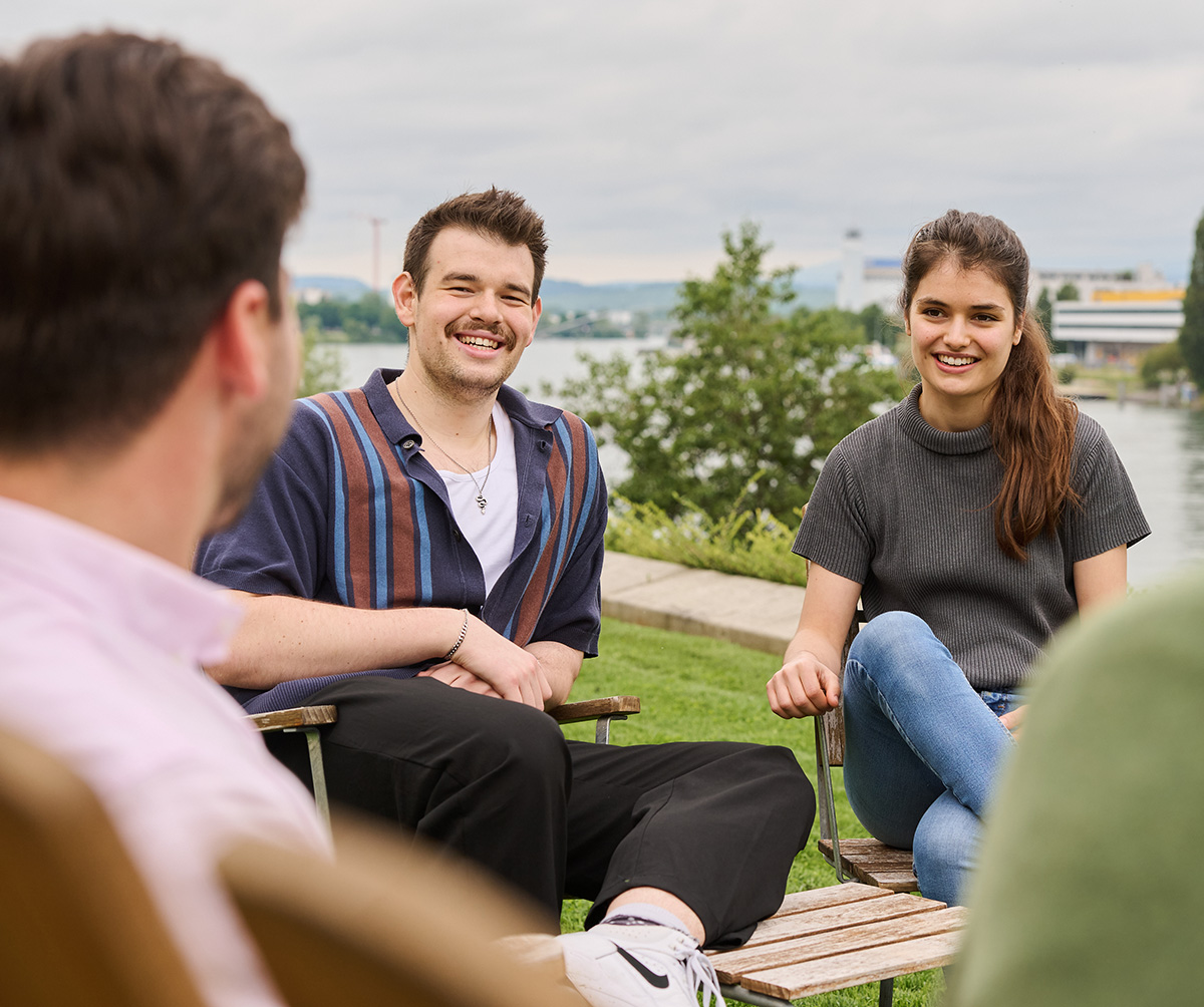 A small group engaged in conversation while seated outdoors