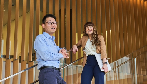 Two business people on stairs smiling