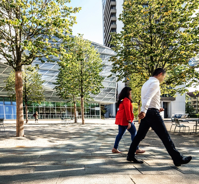 Two persons walking around the Basel campus