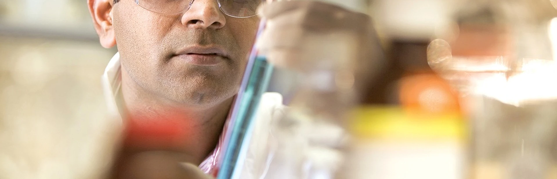 Scientist looking through test tube