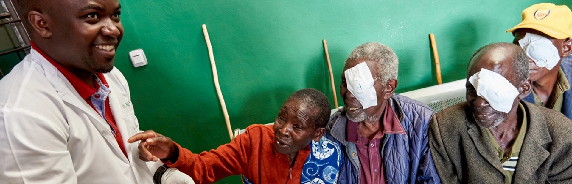 Dr. Theophile Tuyisabe standing next to his patients smiling at him