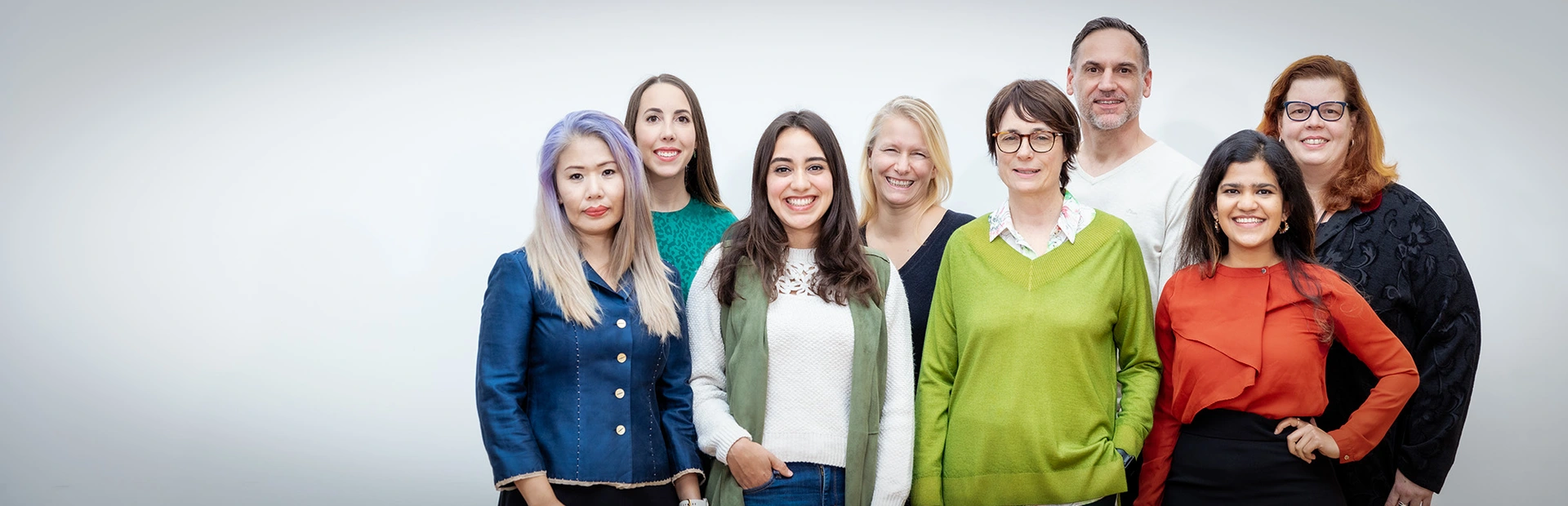 A group portrait of diverse Novartis volunteers in front of a white background, taken in the observance of International Volunteer Day 2022