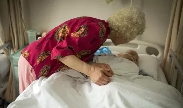 Elder woman holding hand of a patient