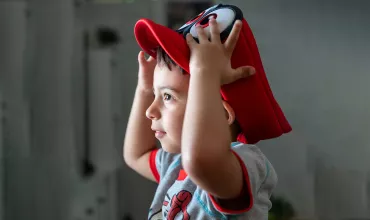 Boy holding his red hat