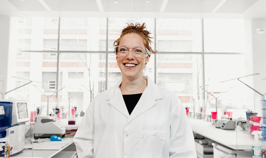 Smiling scientist in a lab wearing security glasses