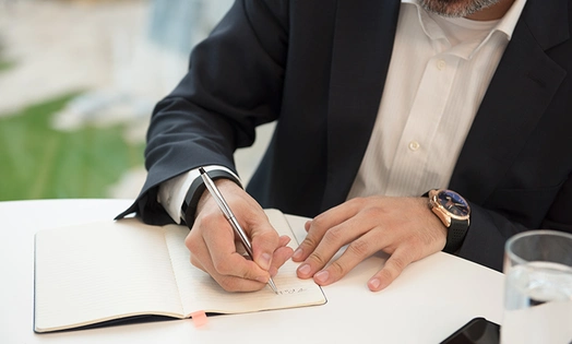 A man holding a pen above paper