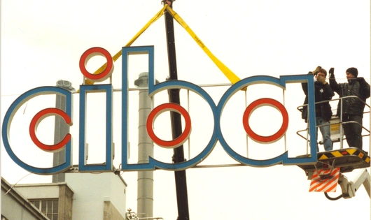 Crane operators taking down a Ciba sign