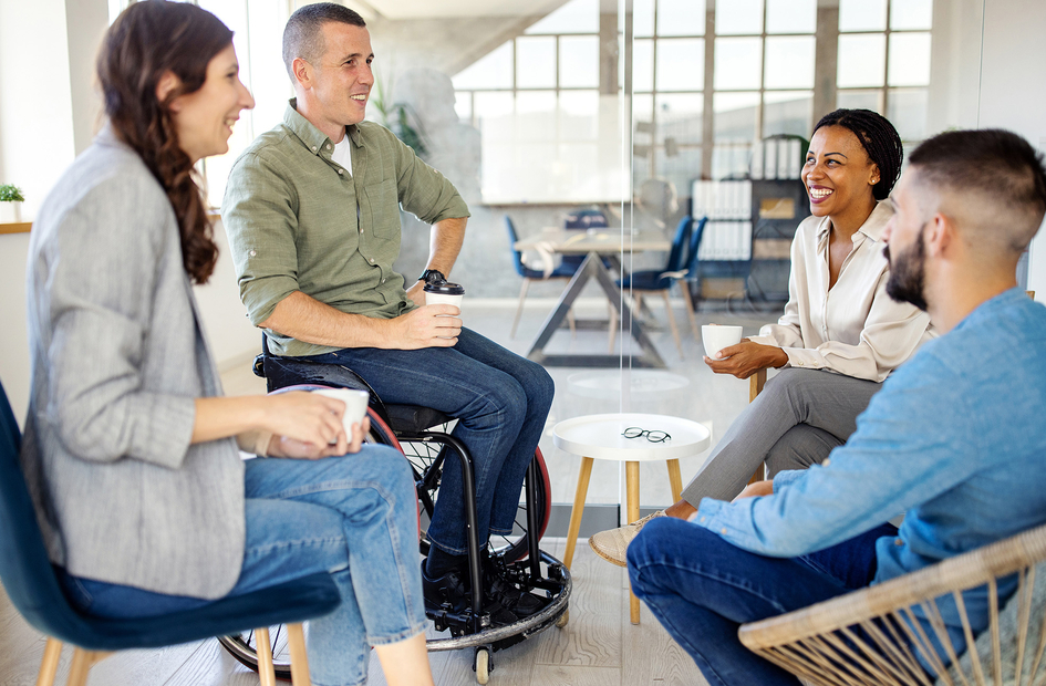 Group of four business people discussing and laughing