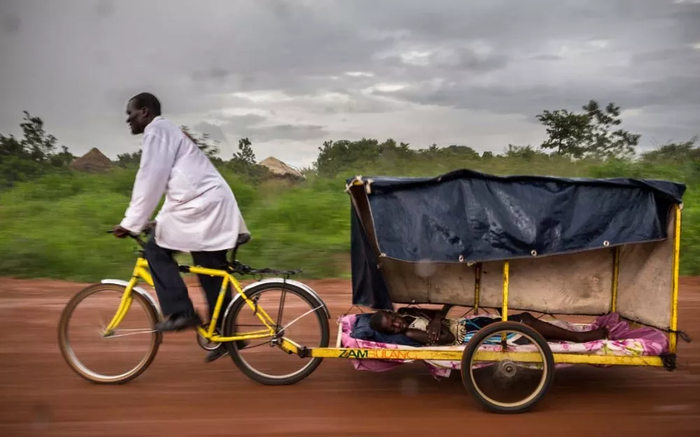 Healthcare worker uses cycle ambulance in fight against malaria in rural Zambia.