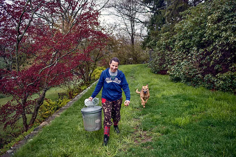 Jennifer walking in a garden with her dog