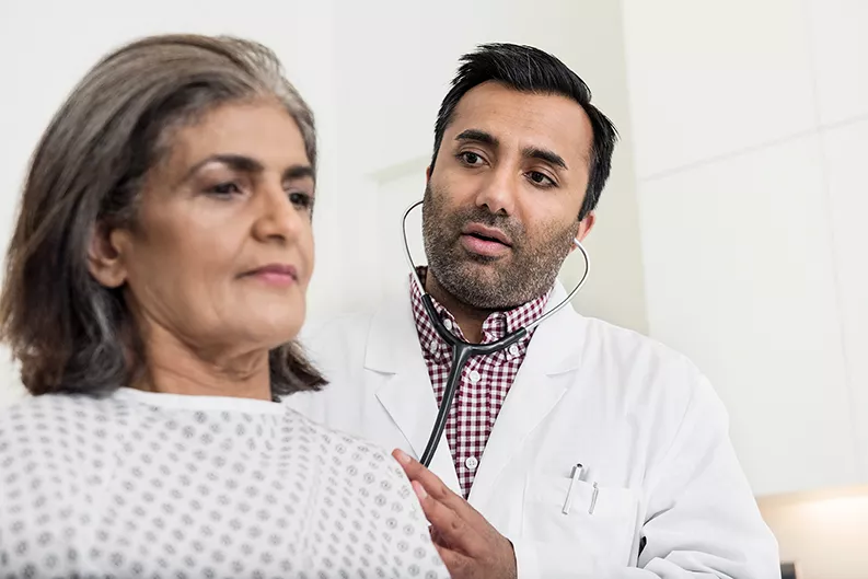 Doctor examines patient by listening to their heartbeat