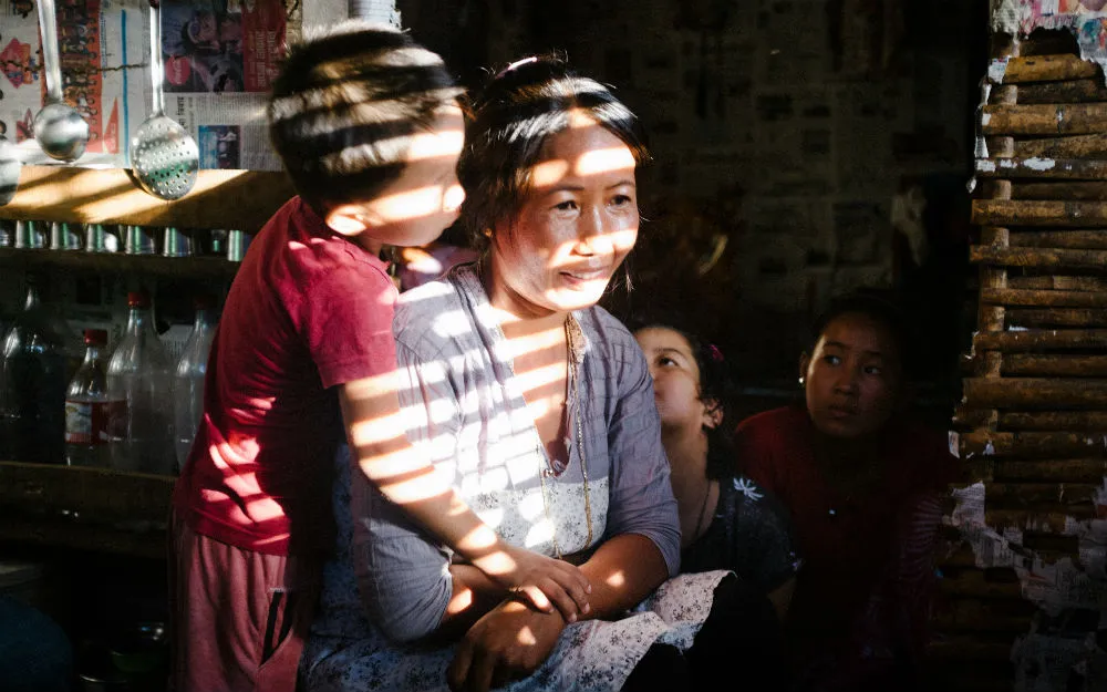 Manmaya is hugged by her son at her home in Nepal
