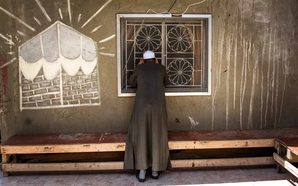 Mohammad peers into a building used as a mosque by Syrian refugees.