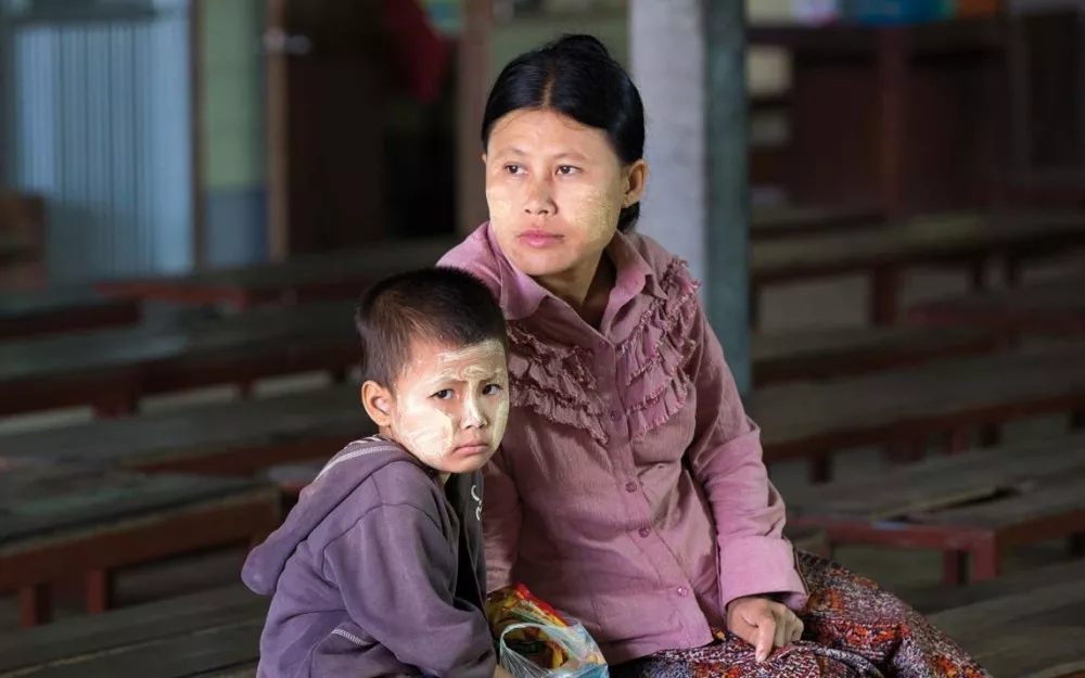 Burmese mother and child, who has symptoms of malaria, waiting in the Wang Pha clinic.
