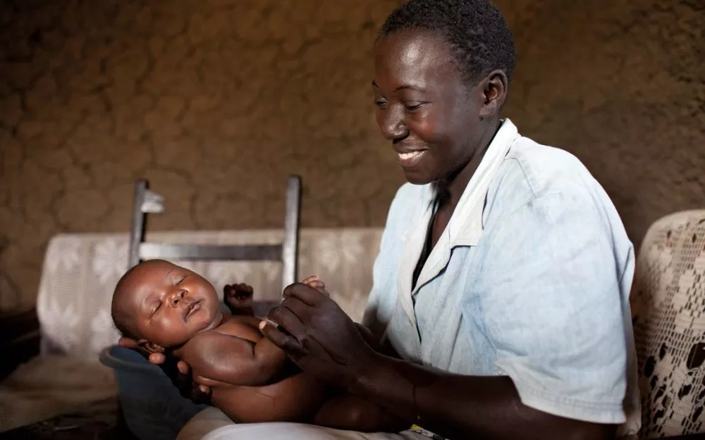 Nurse takes care of newborn in a malaria-endemic region of Kenya.