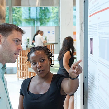 Dr. Ngcungcu presents her scientific paper to a colleague.