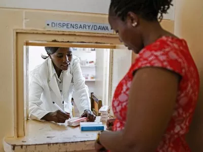 Woman receiving medicine at dispensary in Kenya