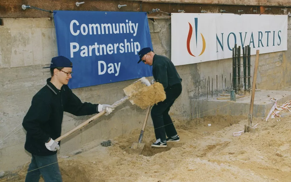 Two Novartis employees help dig building foundations