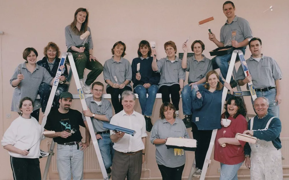 A group of Novartis employees with paintbrushes pose together