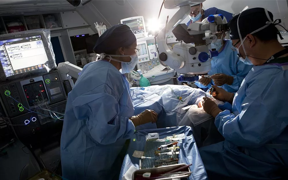 Several doctors in training work together with their teacher during an eye surgery