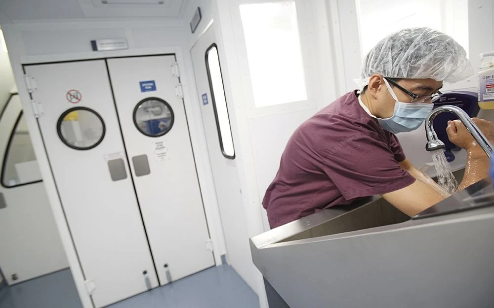 Dr. Zhang washes up before an eye procedure