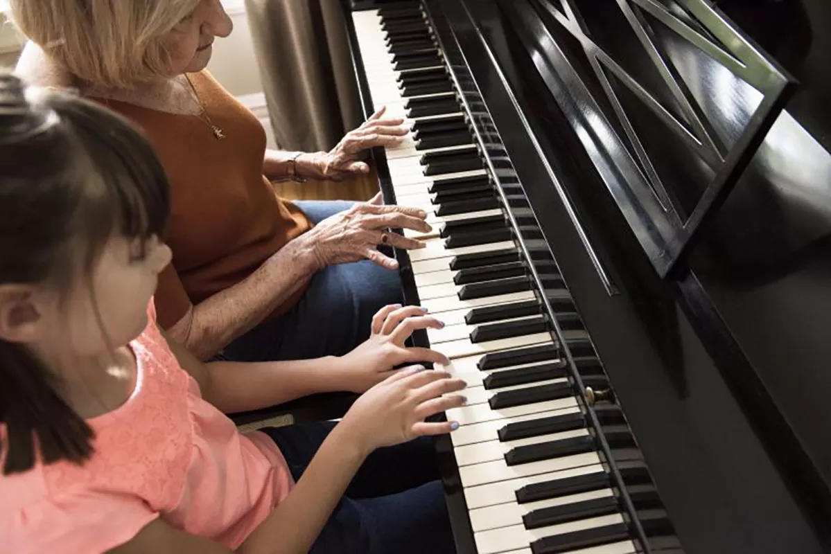 Woman and girl playing a piano