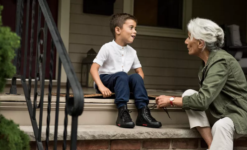 Grandmother tying her grandson's shoe laces