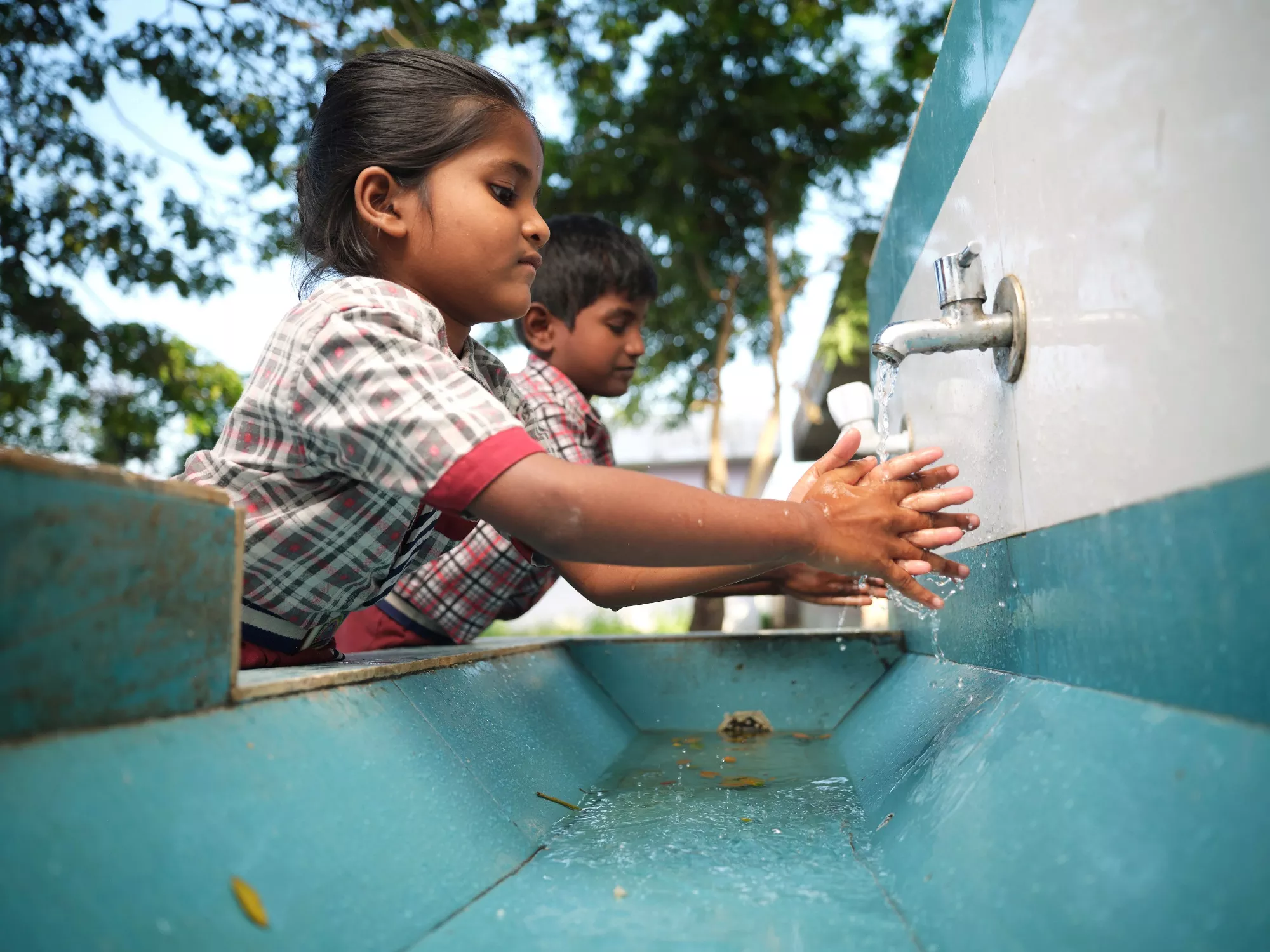 Children washing their hands at their school in Imam Nagar.