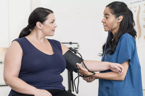 doctor taking the blood pressure of her patient