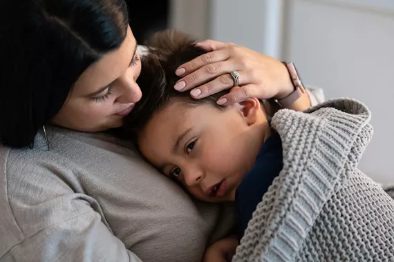 Mother comforts son with migraine