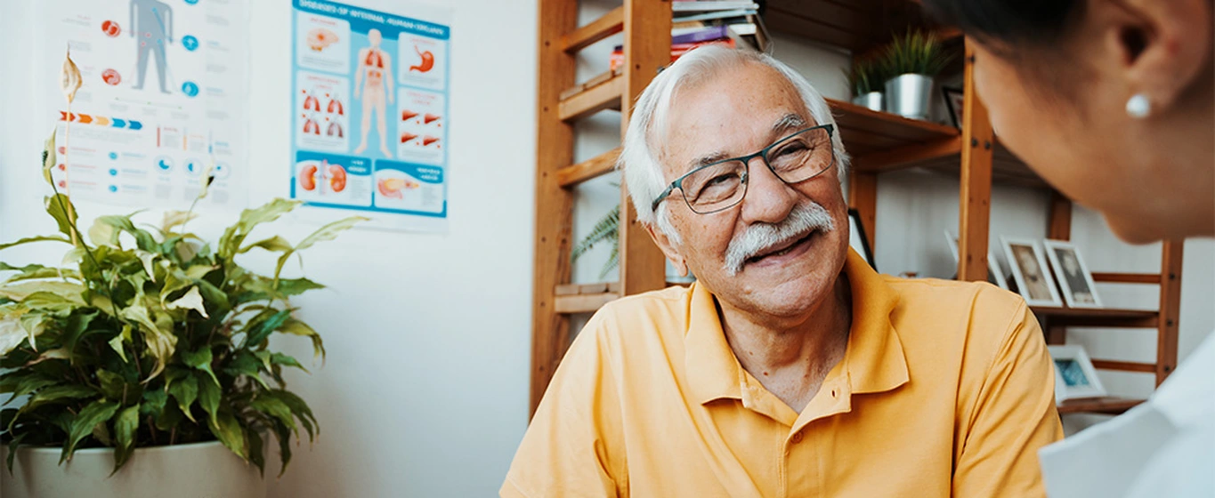 A healthcare professional and senior patient in a conversation using a tablet