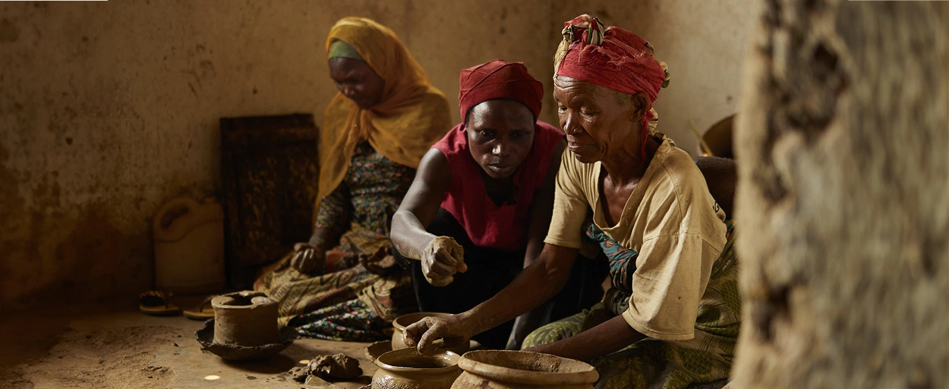 Three women making ceramic pots in Rwanda