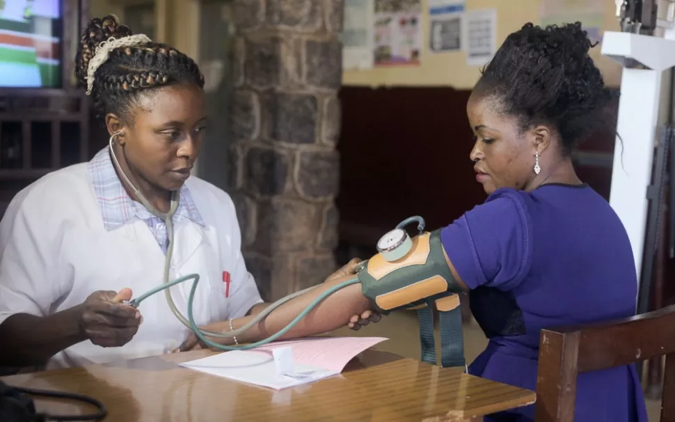 Cordel Ndasi, a nurse at the Etoug-Ebe Baptist Hospital, measures a patient’s blood pressure.