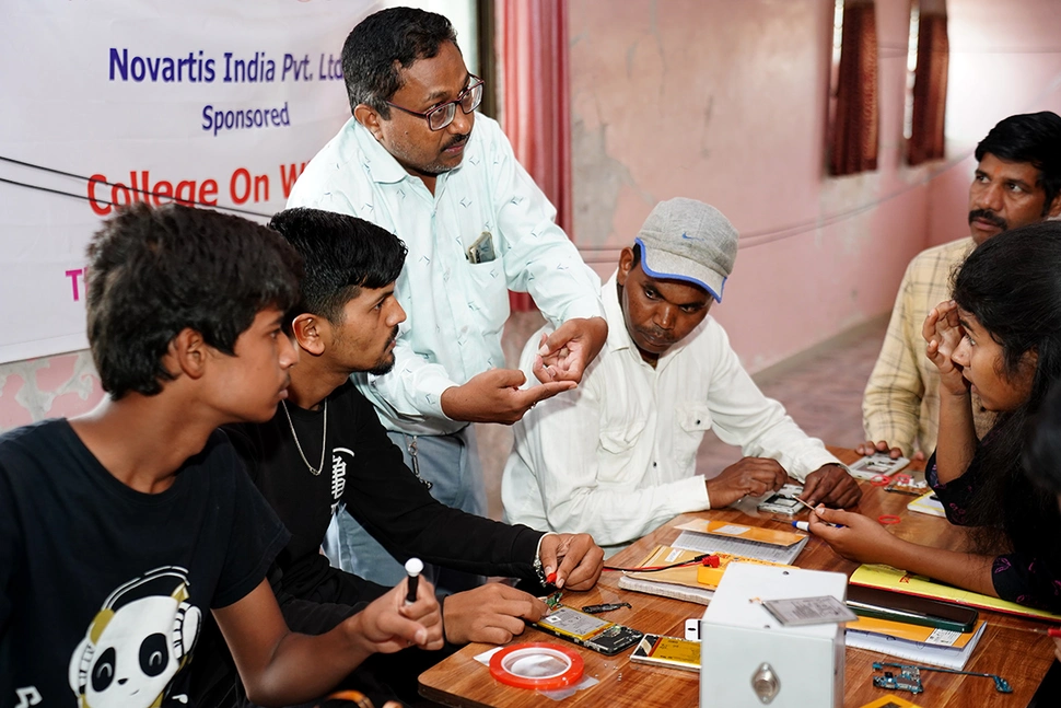 An instructor educates a group of people about electrical engineering.