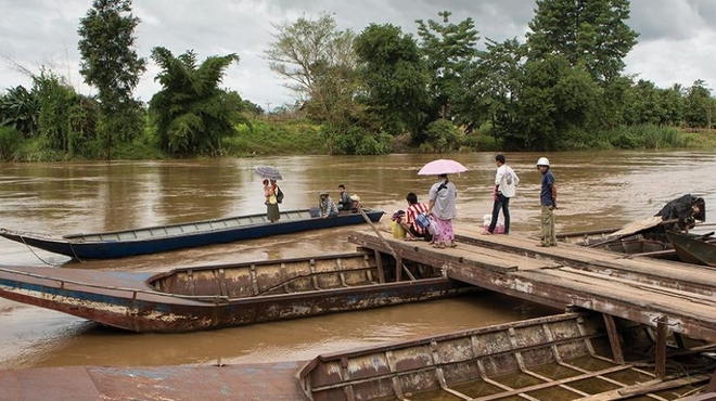 Tribal migrants cross the river separating Myanmar from Thailand Boats in Thailand