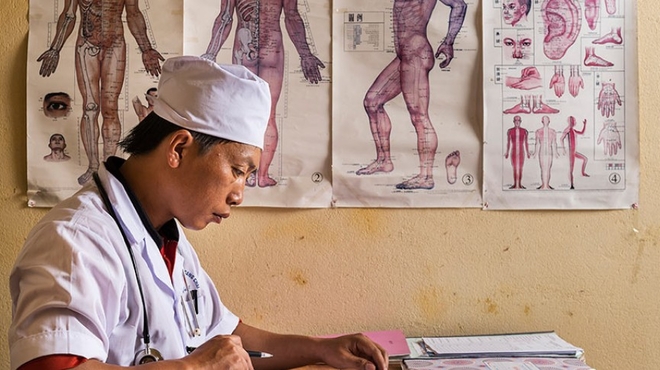 Dr. Chang As Xinh, 37, one of just 15 doctors who deliver medical care to more than 40,000 people in Mù Cang Chải, a rural district of Yen Bai province in northeast Vietnam. Dr. Chang As Xinh updates a patient's medical records at his surgery in Mù Cang Chải, Vietnam.