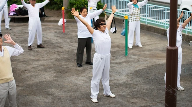 Yuko Yoshikawa and others partake in a communal fitness session outdoors in Tokyo.