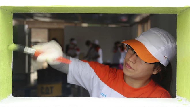 A Novartis employee paints a window frame
